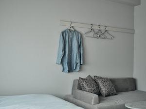 Cette chambre dispose d'un canapé et d'un manteau accroché au mur. dans l'établissement fav HIROSHIMA STADIUM, à Hiroshima