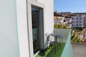 einen Balkon mit einem Tisch und Stühlen sowie einem Fenster in der Unterkunft Casa Avé Maria in Fátima