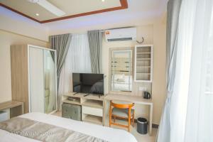 Schlafzimmer mit einem Bett und einem Schreibtisch mit einem Computer in der Unterkunft Avoca Inn in Hulhumale