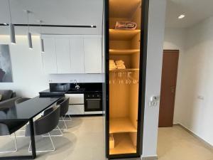 萨兰达Domi Luxury beach view apartments in Saranda的厨房配有白色橱柜和黑色桌椅