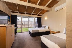 a hotel room with two beds and a balcony at Torquay Hotel/Motel in Torquay