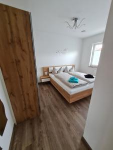 um quarto com uma cama e uma porta de madeira em Ferienwohnung Jekarie em Veimar