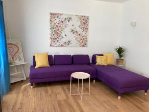 um sofá roxo numa sala de estar com uma mesa em Nina Pinta em Olbia