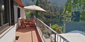 ジェレスにあるCasa do Avô Xico - Gerês Lake House - 10paxのバルコニー(テーブル、傘付)