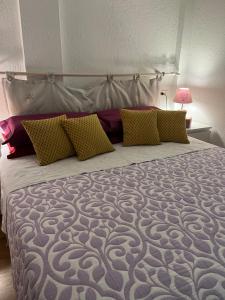 a bedroom with a large bed with yellow and purple pillows at Chalet Blanc "Le Flocon" in Courmayeur