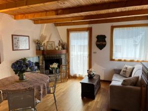 a living room with a couch a table and a fireplace at Chalet Blanc "Le Flocon" in Courmayeur