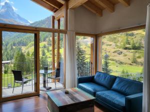 een woonkamer met een bank en uitzicht op een berg bij House Mojo in Zermatt