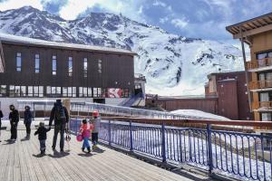 un gruppo di persone che si trovano su una passerella di fronte a una montagna di Belambra Clubs Arc 2000 - L'Aiguille Rouge - Ski pass included ad Arc 2000