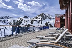 una fila di sedie a sdraio su una terrazza con montagna di Belambra Clubs Arc 2000 - L'Aiguille Rouge - Ski pass included ad Arc 2000