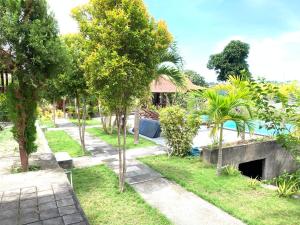 um jardim com árvores e uma piscina em Bukit Permata Lembongan em Nusa Lembongan