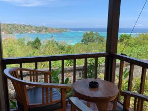 uma varanda com mesa e cadeiras e vista para o oceano em Bukit Permata Lembongan em Nusa Lembongan