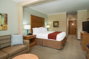 a hotel room with a large bed and a couch at Holiday Inn Express & Suites Santa Clara - Silicon Valley, an IHG Hotel in Santa Clara