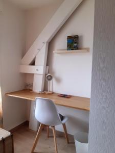 a desk and a chair in a room with a staircase at Kerlann Bruz in Bruz