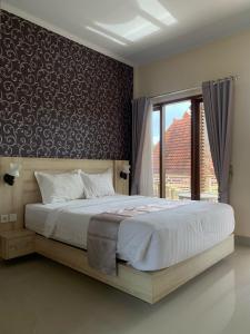 A bed or beds in a room at North Wing Canggu Resort