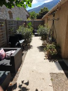 d'un jardin avec une terrasse meublée de chaises et de plantes. dans l'établissement Casa Petra, à Corte