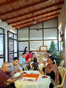 um grupo de pessoas sentadas numa mesa num restaurante em La Maison Pondichéry em Pondicherry