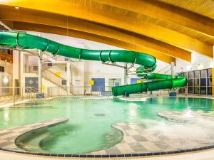 a swimming pool with a water slide in a building at Hotel Mrągowo Resort&Spa in Mrągowo