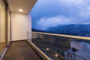 een kamer met een balkon met uitzicht bij Silver Mist in Kodaikānāl