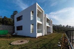 een wit huis met een tuin ervoor bij Silver Mist in Kodaikānāl