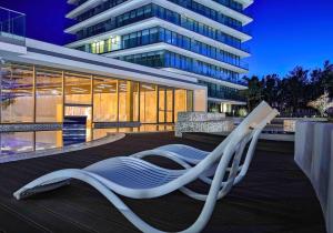 einem weißen Sessel auf einer Terrasse vor einem Gebäude in der Unterkunft Wave Międzyzdroje Resort & SPA in Misdroy