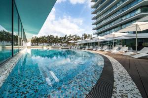 einen Pool mit Liegestühlen und ein Gebäude in der Unterkunft Wave Międzyzdroje Resort & SPA in Misdroy