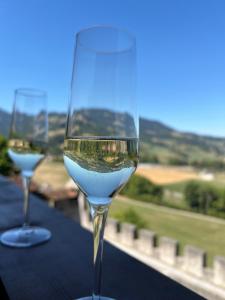 zwei Gläser Weißwein auf dem Tisch in der Unterkunft Hôtel de Ville in Gruyères