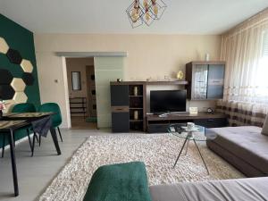 een woonkamer met een bank en een tafel bij Bella Apartman Debrecen in Debrecen