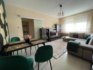 een woonkamer met een bank en een tafel en stoelen bij Bella Apartman Debrecen in Debrecen