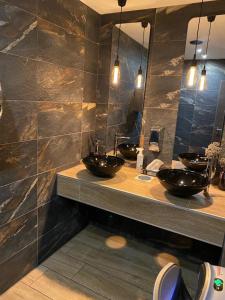 a bathroom with two sinks and two mirrors at OLÉ Hotel in Hamburg