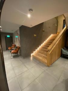 a lobby with stairs and chairs in a building at OLÉ Hotel in Hamburg