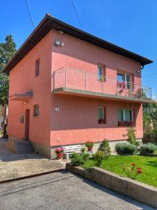 une maison rouge avec un balcon latéral dans l'établissement Guest House Bosnian House, à Sarajevo