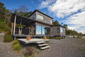 una casa con un banco delante de ella en Cala Melí, en Puerto Varas