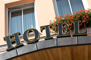 a sign on the front of a building with flowers at Hotel Für Dich in Waren