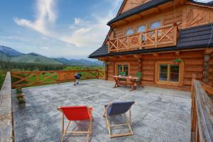 une cabane en bois avec des chaises et une table sur une terrasse dans l'établissement Willa ANTONÓWKA, à Kościelisko