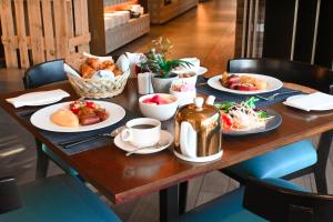 una mesa con platos de comida y tazas de café en Wyndham Dubai Deira, en Dubái