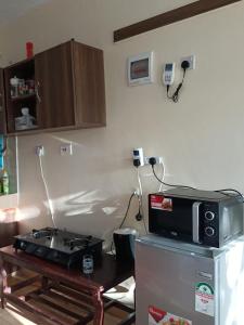 una cucina con forno a microonde e frigorifero di Mkombodzi Global Homes a Mtwapa