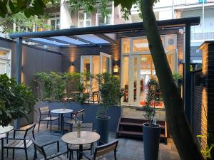 un patio extérieur avec des tables, des chaises et des plantes dans l'établissement Alp Hotel, à Amsterdam