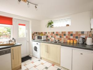 a kitchen with a sink and a washing machine at Pen Dinas in Bangor