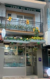 un edificio con un balcón con flores. en Hostal Boutique Luna de Gavín, en Cullera