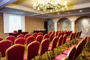 uma sala de conferências com cadeiras vermelhas e um ecrã de projecção em Hotel St. Bruno em Giżycko