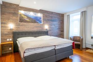 a bedroom with a bed and a brick wall at Hotel Europe in Davos