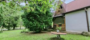 een tafel voor een huis met een boom bij Villa ORKA Pelister - Forest Zone in Bitola