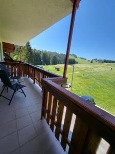 einen Balkon mit Stühlen und Blick auf ein Feld in der Unterkunft Kamzik Apartment hill view with garage in Donovaly