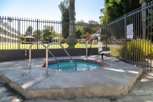 una piccola piscina con scivolo di fronte a una recinzione di San Clemente Inn a San Clemente