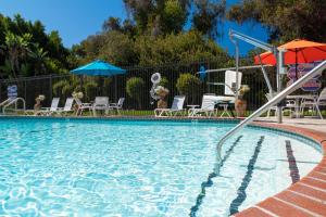 una grande piscina con sedie e ombrelloni di San Clemente Inn a San Clemente