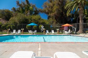 una piscina con sedie e ombrelloni di San Clemente Inn a San Clemente