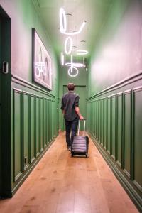 a man walking down a hallway with a suitcase at Joro Living in Paris