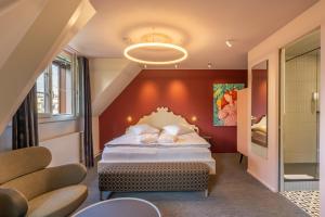 - une chambre avec un grand lit et un mur rouge dans l'établissement BOUTIQUE Hotel by Continental Park, à Lucerne