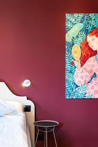 - une chambre avec un mur rouge orné d'une peinture murale dans l'établissement BOUTIQUE Hotel by Continental Park, à Lucerne