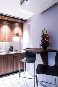 a kitchen with wooden cabinets and a table and chairs at Studios Astra Hotel Vevey in Vevey